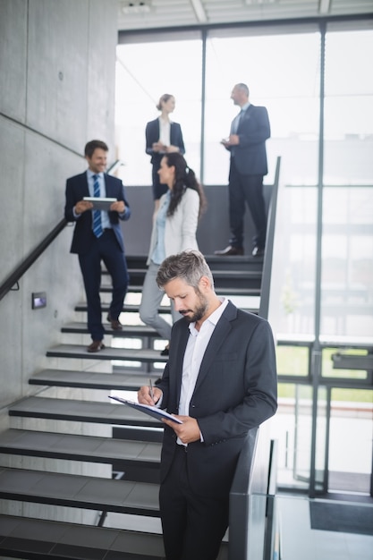 Foto grátis empresário escrevendo na área de transferência