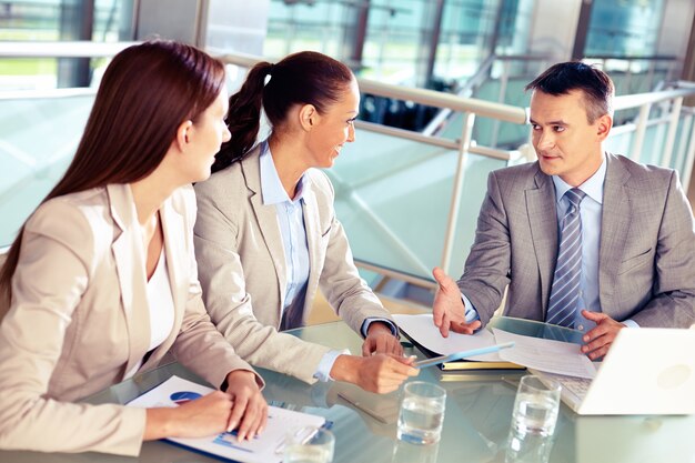 Empresário explicando o plano financeiro para os colegas de trabalho