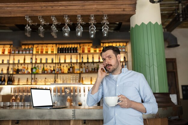 Empresário falando ao telefone em um café.