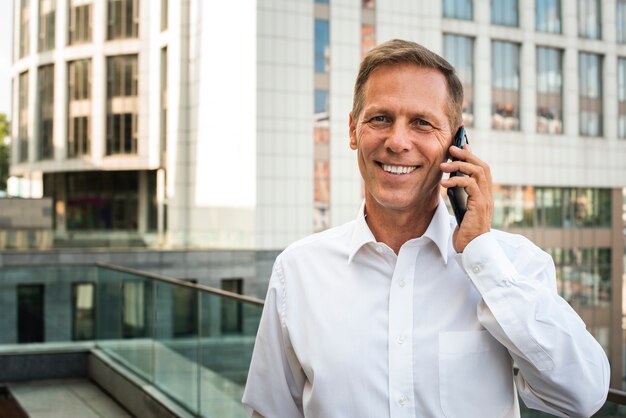 Empresário falando ao telefone, olhando para a câmera