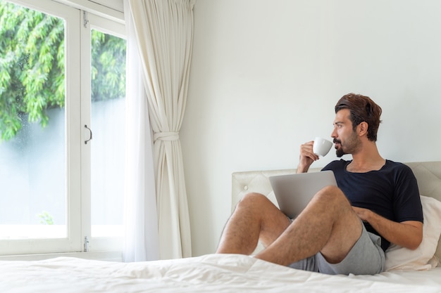 Foto grátis empresário feliz bebendo café durante o trabalho no escritório doméstico