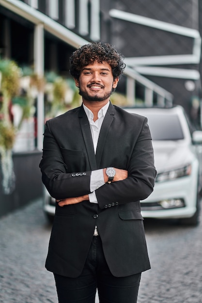 Empresário indiano com seu carro branco.