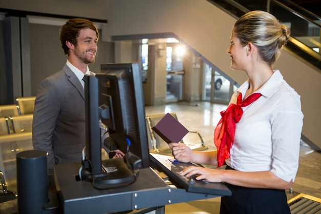 Foto grátis empresário interagindo com funcionárias do aeroporto no balcão de check-in