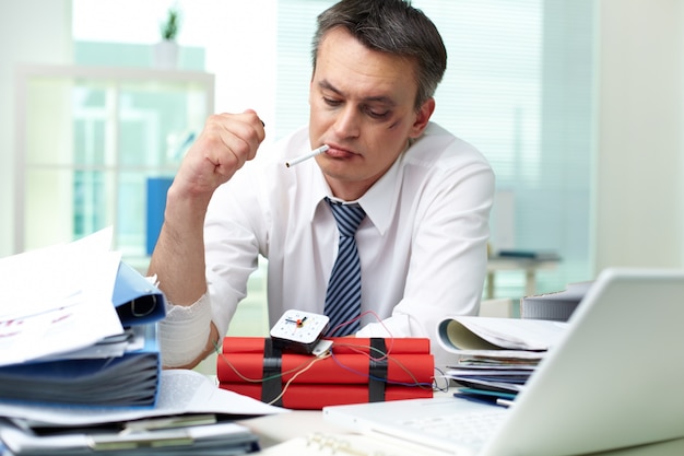 Foto grátis empresário pensando enquanto fuma um cigarro