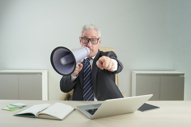 Empresário sênior usando megafone