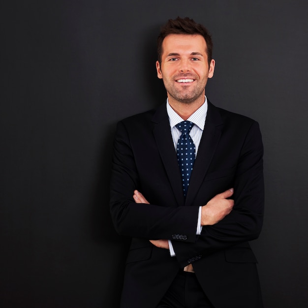 Empresário sorridente com os braços cruzados