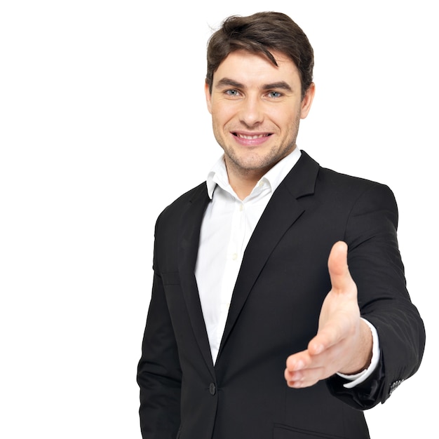 Empresário sorridente em terno preto dá aperto de mão isolado no branco.