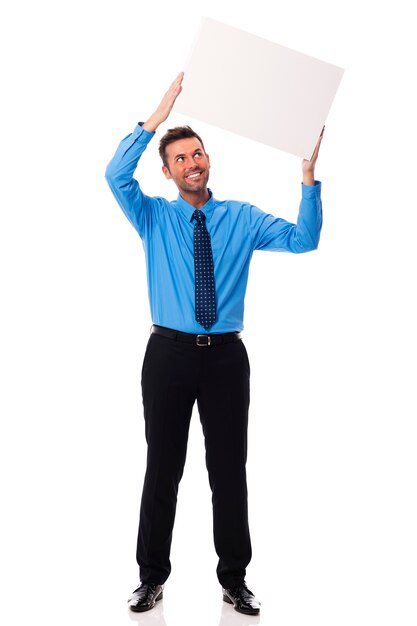 Empresário sorridente segurando um cartaz em branco