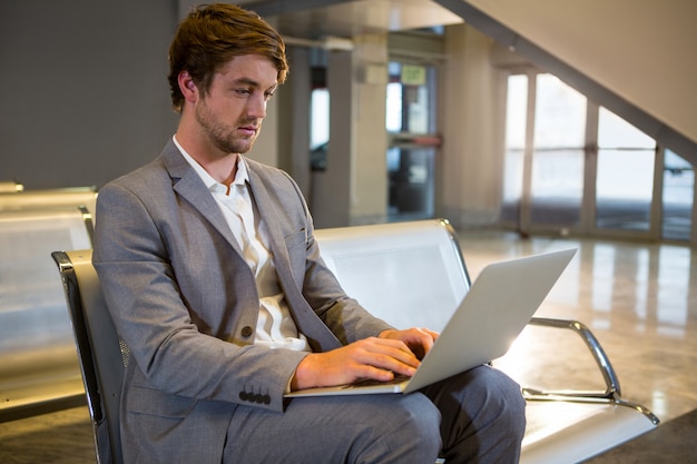 Empresário trabalhando em seu laptop na sala de espera