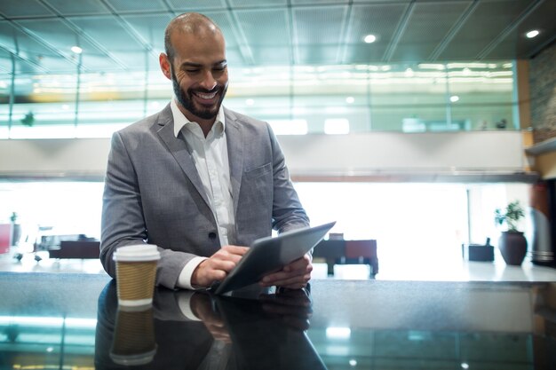 Empresário usando tablet digital na sala de espera