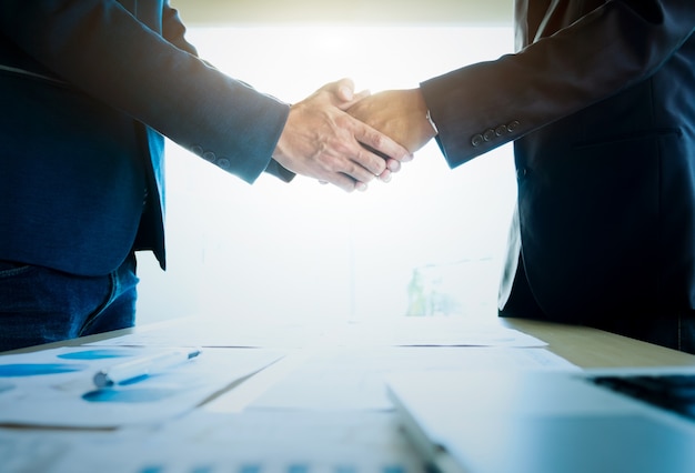 Empresários apertando as mãos durante uma reunião.