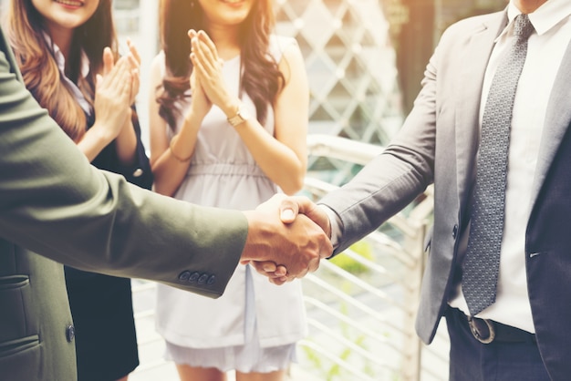 Empresários apertando as mãos, terminando um acordo de sucesso da reunião.