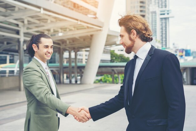 Empresários felizes apertando as mãos. Sucesso empresarial.