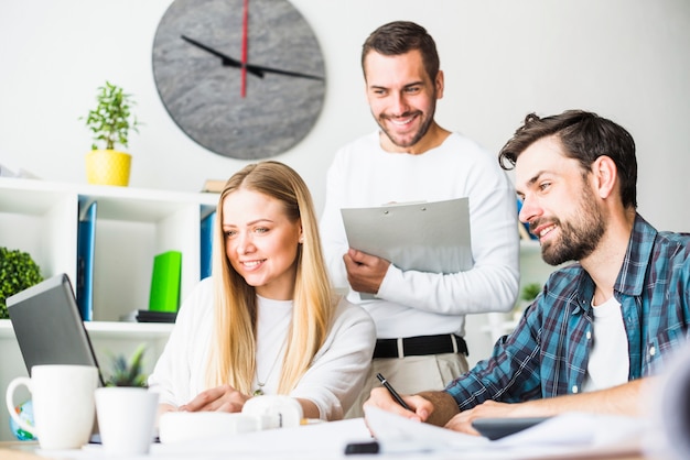 Empresários masculinos e femininos felizes trabalhando no laptop