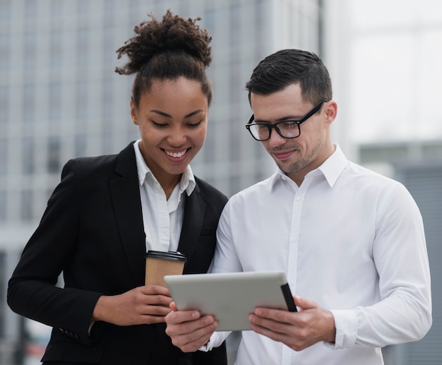 Empresários olhando ipad tiro médio