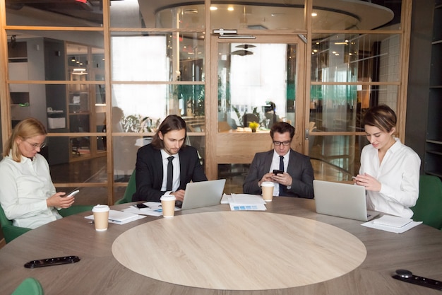 Foto grátis empresários usando dispositivos durante a reunião de negócios da empresa