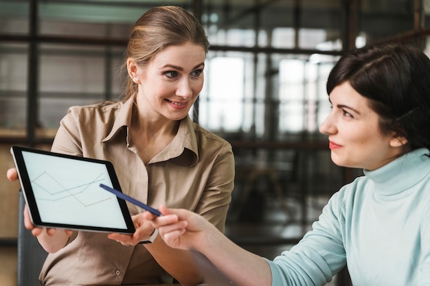 Empresários usando tablet durante reunião em ambiente fechado