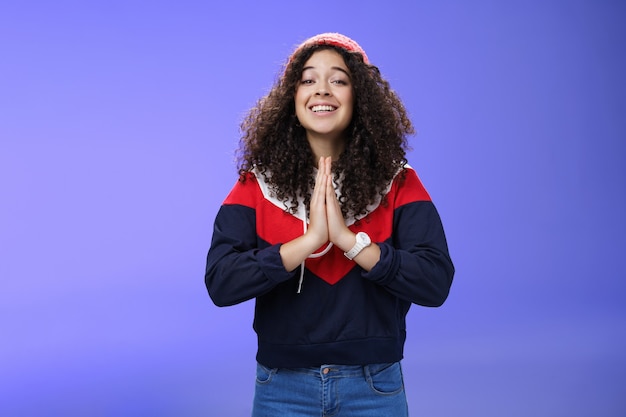 Encantadora, animada e simpática amiga fofa com penteado encaracolado no chapéu ao ar livre e sué ...