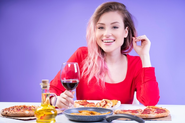 Encantadora dama de blusa vermelha, sentado à mesa com um copo de vinho