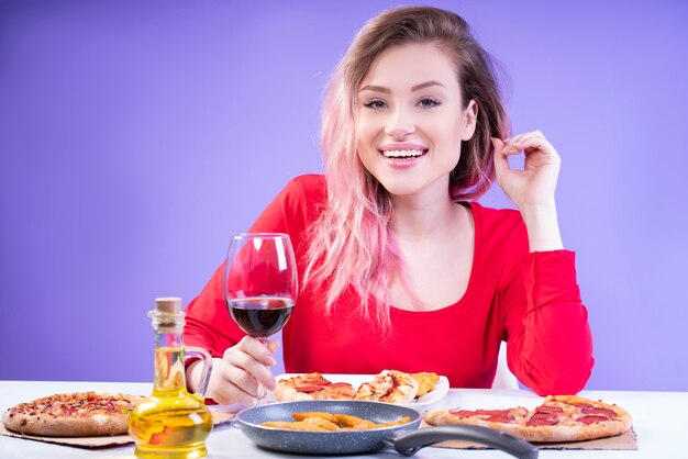 Encantadora dama de blusa vermelha, sentado à mesa com um copo de vinho