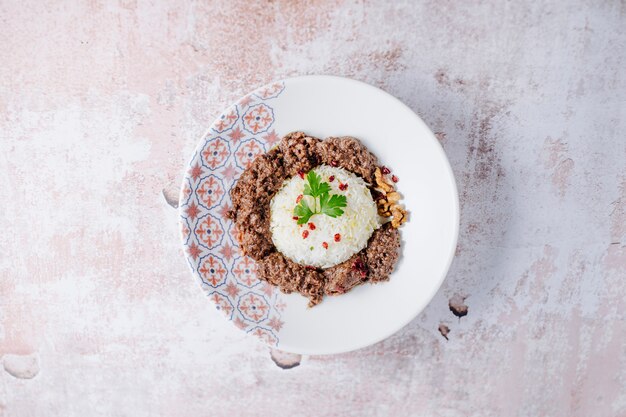 Enfeite de arroz com bolas de carne em chapa branca.