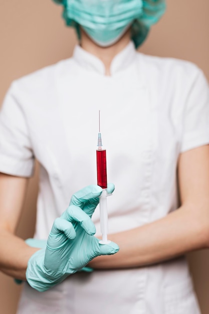 Foto grátis enfermeira com uma seringa na mão enluvada