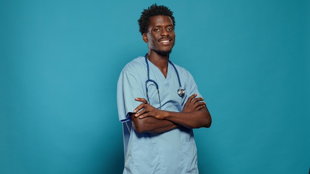 Foto grátis enfermeira confiante, cruzando os braços e olhando para a câmera. assistente médico vestindo uniforme e estetoscópio enquanto sorria. especialista profissional que trabalha como profissional de saúde