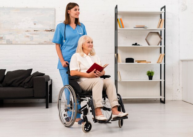 Enfermeira cuidando da mulher em cadeira de rodas
