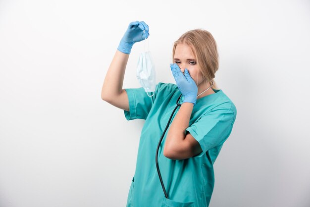 Enfermeira de uniforme com máscara e luvas de látex. Foto de alta qualidade