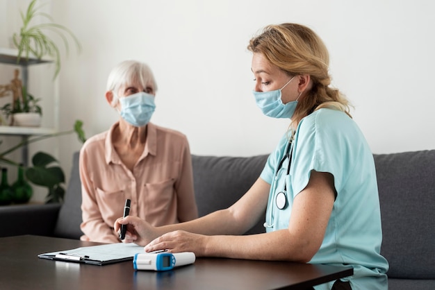 Enfermeira e idosa durante um check-up em uma casa de repouso