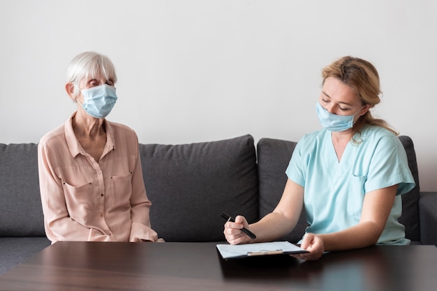 Foto grátis enfermeira fazendo um check-up com uma mulher mais velha em uma casa de repouso