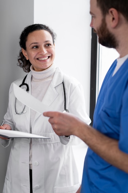 Enfermeira sorridente e médico conversando