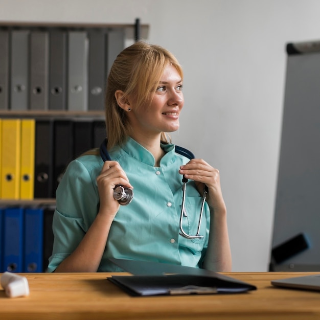 Enfermeira sorridente no escritório com laptop