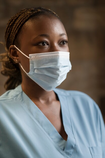 Enfermeira vestindo jaleco e máscara médica na clínica