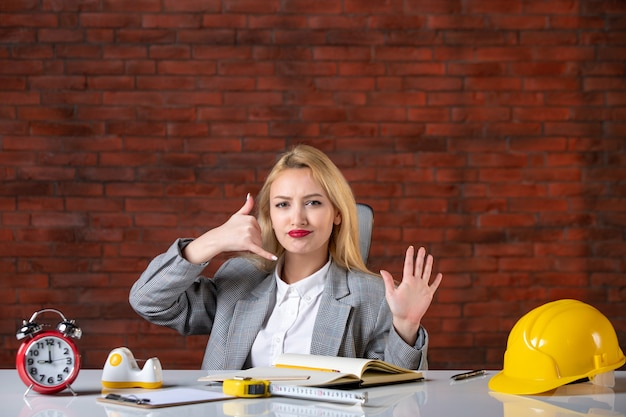 Engenheira de frente, sentada atrás de seu local de trabalho