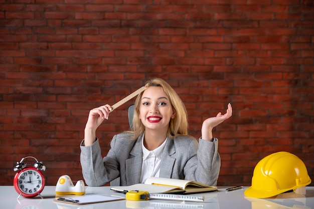 Engenheira de frente, sentada atrás de seu local de trabalho