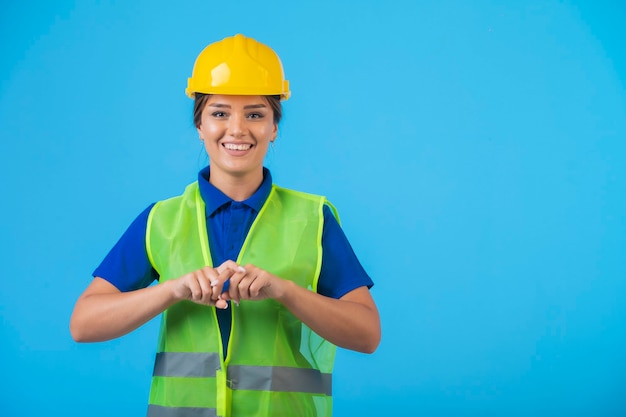 Engenheira em capacete amarelo e equipamento, sentindo-se confiante.