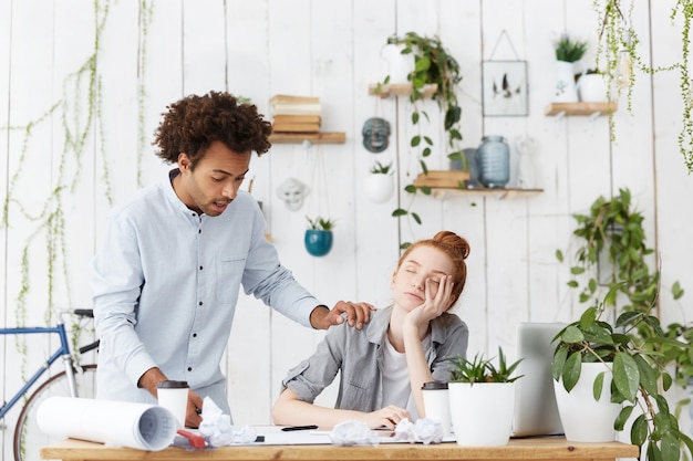 Engenheiro afro-americano surpreso, encontrou sua colega de trabalho dormindo no local de trabalho