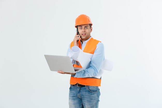 Foto grátis engenheiro, arquiteto, com cara ocupada fala no smartphone enquanto segura plantas. homem, capataz no capacete falando no telefone, fundo vermelho. arquiteto chamando engenheiro para consertar o plano. conceito de comunicação.