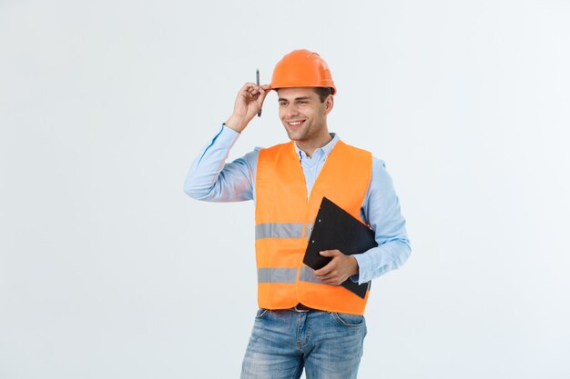 Engenheiro de construção sorridente posando isolado sobre fundo cinza.