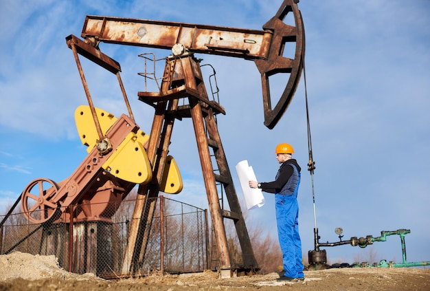 Engenheiro de petróleo controlando o trabalho do jack da bomba do poço de petróleo