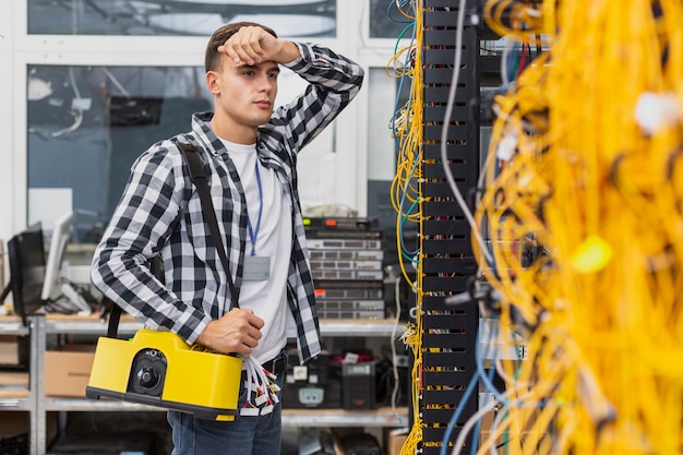 Engenheiro de rede cansado com uma caixa trabalhando em switches ethernet