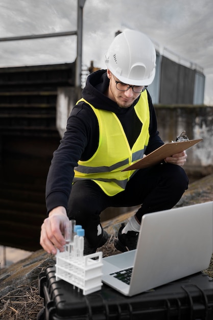 Engenheiro de tiro completo com laptop do lado de fora