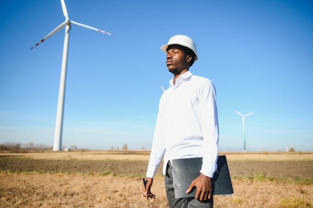 Engenheiro homem africano em pé com turbina eólica