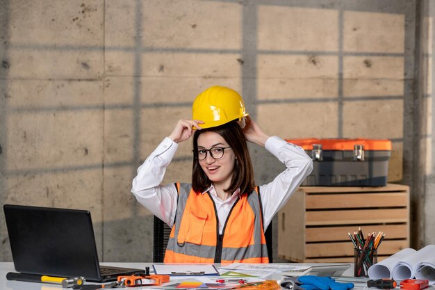Engenheiro jovem bonito inteligente garota morena trabalhador civil em capacete e colete terminou o trabalho