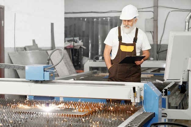 Foto grátis engenheiro profissional que controla o processo de corte a plasma