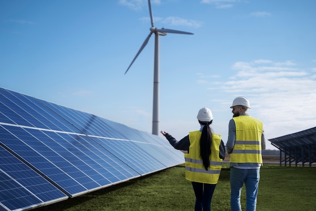 Engenheiros de tiro médio discutindo sobre painéis solares