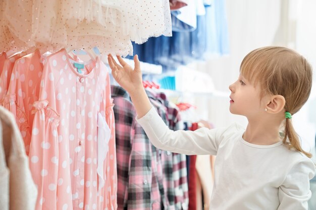 Engraçadinha, olhando para o lindo vestido rosa na loja