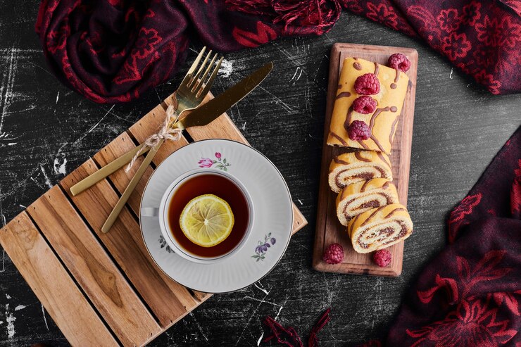 Foto grátis enrole o bolo com chocolate, frutas vermelhas e uma xícara de chá.
