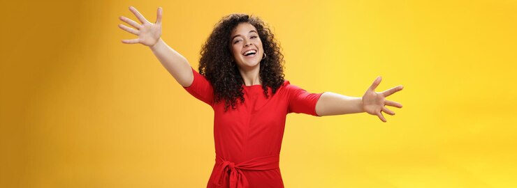 Foto grátis entre em meus braços, retrato de uma mulher charmosa, simpática e amorosa, com cabelos cacheados em casua vermelha